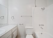 Thumbnail 68 of 70 - A white bathroom with a toilet, sink, and bathtub.