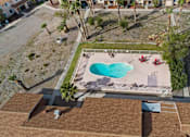 Thumbnail 2 of 10 - A swimming pool with a heart design in the middle of a backyard.