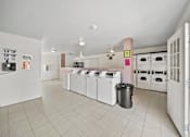Thumbnail 9 of 10 - A kitchen with white appliances and a trash can.