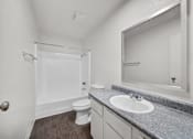 Thumbnail 13 of 13 - A bathroom with a toilet, sink, and mirror.