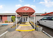 Thumbnail 6 of 13 - A red and white sign with the letters "DGP" is on a red awning over a set of double doors.