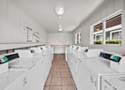 Thumbnail 8 of 13 - A laundromat with rows of washing machines.