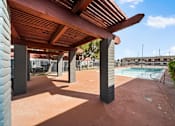 Thumbnail 1 of 13 - A patio with a pool in the background.