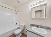 Thumbnail 16 of 21 - A white bathroom with a toilet, sink, and tub.