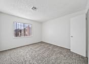 Thumbnail 7 of 21 - A room with a window and carpeted floor.