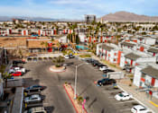 Thumbnail 11 of 21 - A parking lot with cars and a playground in the middle of a residential area.