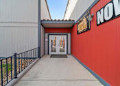 Thumbnail 19 of 21 - A red building with a black railing and a glass door.