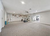 Thumbnail 10 of 21 - A spacious room with a ceiling fan and exercise equipment.