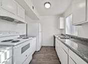 Thumbnail 5 of 21 - A modern kitchen with white appliances and cabinets.