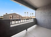 Thumbnail 10 of 17 - A balcony with a railing overlooks a building and palm trees.