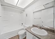 Thumbnail 4 of 17 - A white bathroom with a toilet, sink, and bathtub.