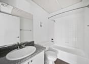 Thumbnail 16 of 17 - A white bathroom with a sink, toilet, and bathtub.