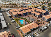 Thumbnail 8 of 17 - A large building complex with a pool in the middle.
