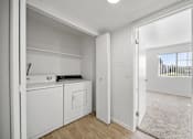 Thumbnail 12 of 17 - A white laundry room with a washer and dryer.