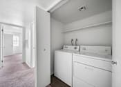 Thumbnail 13 of 17 - A white laundry room with a washer and dryer.