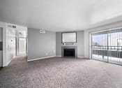 Thumbnail 7 of 17 - A spacious living room with a fireplace and a flat-screen TV.