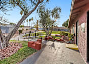 Thumbnail 2 of 9 - A red brick bench sits in the middle of a concrete walkway.