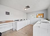 Thumbnail 9 of 9 - A room with white appliances and a brown bench.