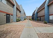 Thumbnail 5 of 11 - A long concrete walkway separates apartment buildings.