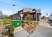 Thumbnail 1 of 11 - A modern building with a green dumpster in front of it.