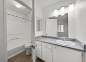Thumbnail 21 of 21 - A bathroom with a toilet, sink, and mirror.