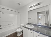Thumbnail 16 of 21 - A white bathroom with a toilet, sink, and mirror.
