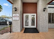 Thumbnail 1 of 21 - The entrance to a building with a sign that reads "Las Palomas" and a black doormat in front.