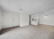 Thumbnail 6 of 21 - A spacious room with a carpeted floor and a ceiling fan.