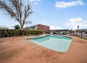 Thumbnail 9 of 21 - A small pool in a backyard with a fence around it.