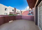 Thumbnail 13 of 75 - A courtyard surrounded by buildings with a clear blue sky.