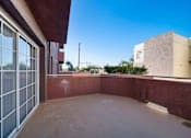 Thumbnail 14 of 75 - A patio with a red wall and a glass door.