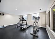 Thumbnail 20 of 75 - A room with a black floor and white walls has a row of exercise equipment.