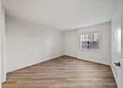 Thumbnail 35 of 75 - A room with wooden flooring and a window with blinds.
