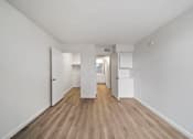 Thumbnail 37 of 75 - A long hallway with white walls and wood flooring.