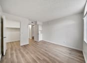 Thumbnail 39 of 75 - A spacious room with light wood flooring and white walls.