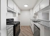 Thumbnail 44 of 75 - A modern kitchen with a black stove top oven and a granite counter top.