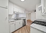 Thumbnail 45 of 75 - A kitchen with white cabinets and a granite countertop.