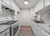 Thumbnail 48 of 75 - A kitchen with a stove top oven and a sink.