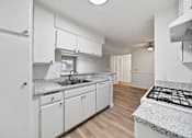 Thumbnail 49 of 75 - A kitchen with white cabinets and a granite countertop.