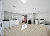 Thumbnail 51 of 75 - A laundry room with washers and dryers.