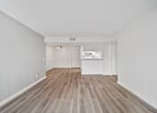 Thumbnail 60 of 75 - A room with wooden flooring and white walls.