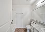 Thumbnail 63 of 75 - A white bathroom with a toilet, sink, and mirror.