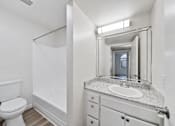 Thumbnail 67 of 75 - A white bathroom with a toilet, sink, and mirror.
