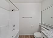Thumbnail 68 of 75 - A white bathroom with a toilet, sink, and bathtub.