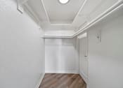Thumbnail 70 of 75 - A white hallway with wood flooring and white walls.