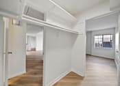 Thumbnail 72 of 75 - A white room with a door on the left and a window with bars on the right.