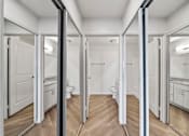 Thumbnail 74 of 75 - A bathroom with a toilet, sink, and mirrors.