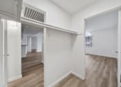 Thumbnail 75 of 75 - A room with white walls and wooden flooring with a doorway leading to another room.