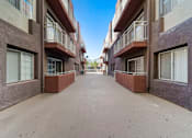 Thumbnail 8 of 75 - A long, narrow alleyway between two buildings with balconies.