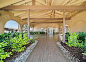 Thumbnail 2 of 28 - A long wooden walkway leads through a landscaped garden.
